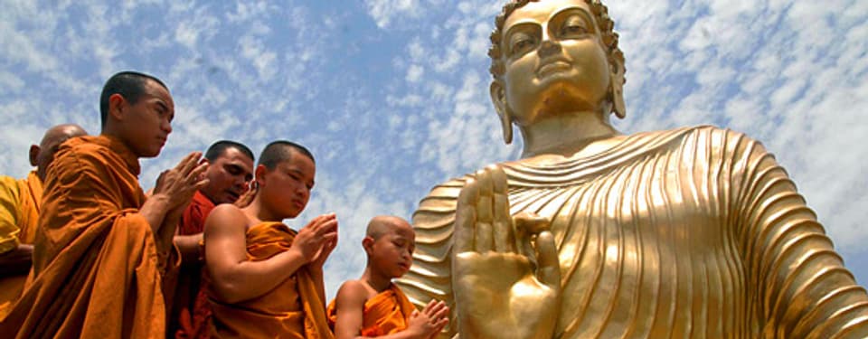 Buddhistische Mönche beten vor einer riesigen Buddha-Statue in Bhopal, Indien.