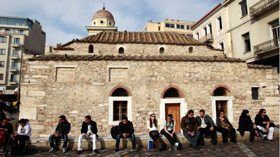 Jugendliche Athener vor einer alten griechisch-orthodoxen Kirche.