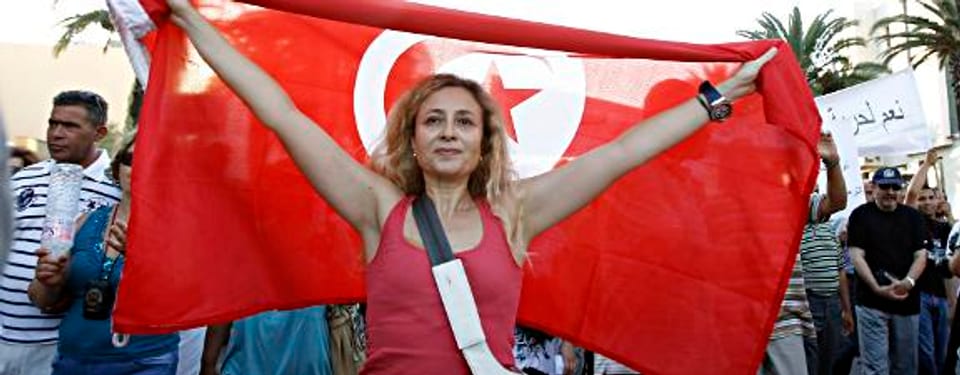 Demonstrantin mit der tunesischen Flagge.
