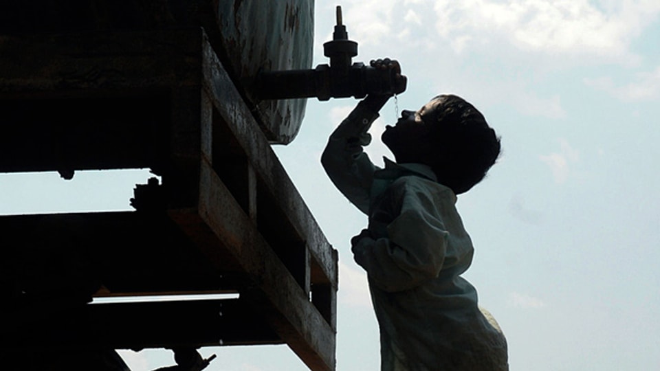 Der Zugang zu Trinkwasser ist ein globales Problem: Ein indischer Junge trinkt ab einem mobilen Tank.