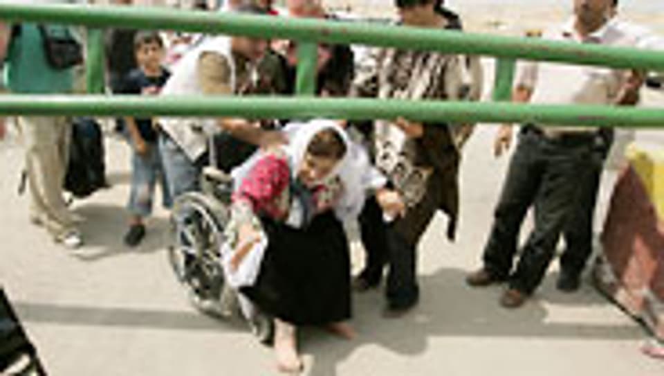 Eine behinderte Frau wartet darauf, die Grenze nach Israel zu überqueren.