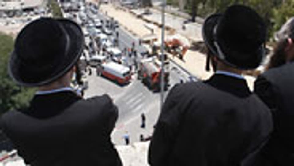 Orthodoxe Juden beobachten die Unfallstelle in Jerusalem.