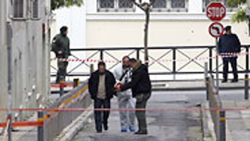 Fahnder untersuchen den Tatort vor dem Kulturministerium in Athen, wo zwei Männer auf eine Gruppe von Polizisten schossen.