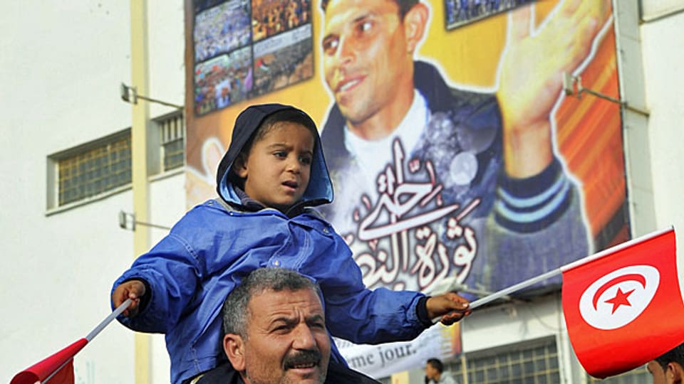 Demonstration gegen den Besuch des tunesischen Präsidenten Moncef Marzouki - vor einem Gedenkbild für Mohammed Bouazizi.