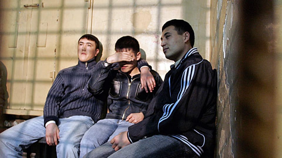 Drei ausländische Arbeiter, die anlässlich einer Raziia auf einem Moskauer Markt festgenommen wurden.