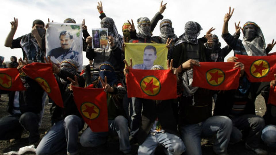 Maskierte Männer posieren mit dem Bild des Kurdenführers Abdullah Öcalan.