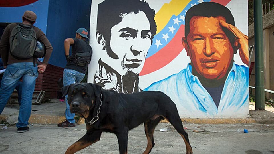 Hugo Chavez neben Simon Bolivar an einer Wand in der venezolanischen Hauptstadt Caracas.