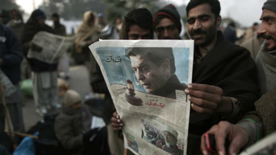 Qadri-Anhänger lesen die Schlagzeilen zur Verhaftung von Premier Ashraf