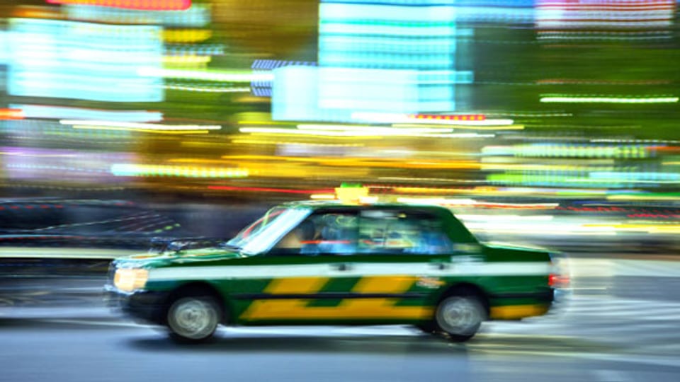 Damals wie heute: Ein Taxi auf rasanter Fahrt durch Tokio.