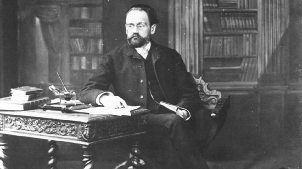 Émile Zola an seinem Schreibtisch sitzend