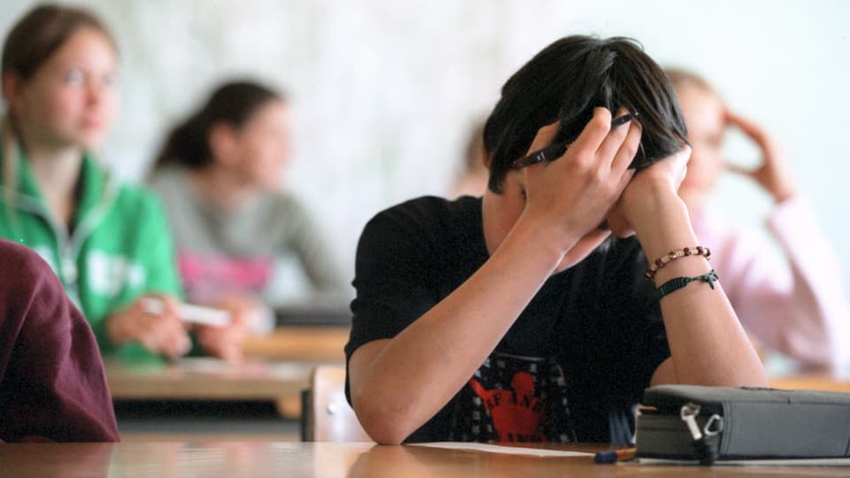Schüler bei einer Prüfung stützt den Kopf ab