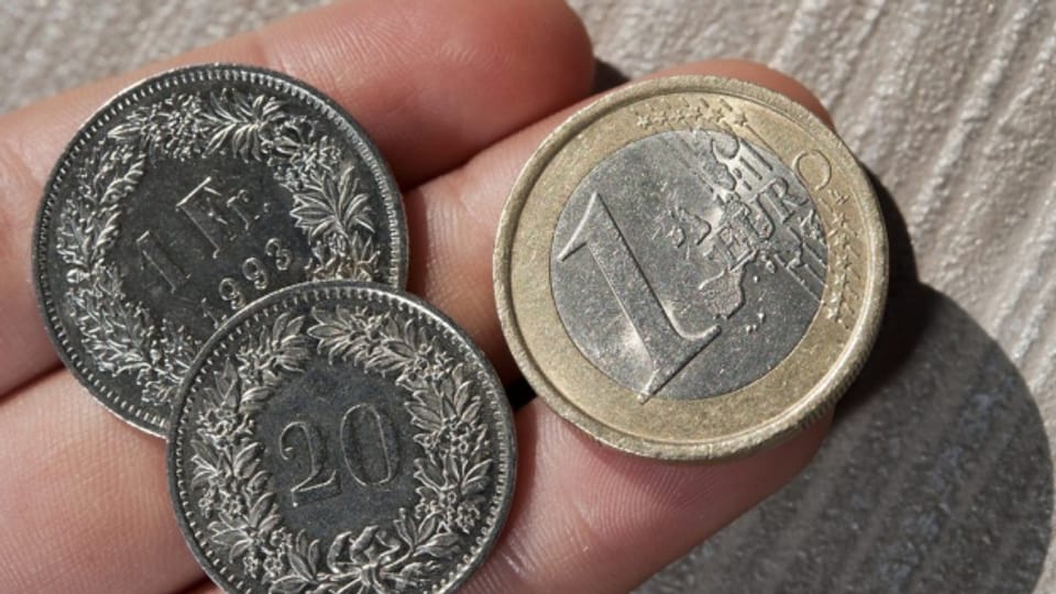 Auf einer Hand sind 1.20 Franken und 1 Euro zu sehen.