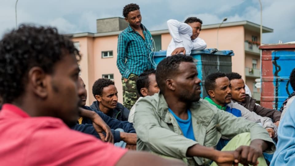 Eritreer vor einer Asylunterkunft.