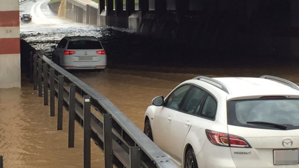 Zwei Autos auf einer überschwemmten Strasse