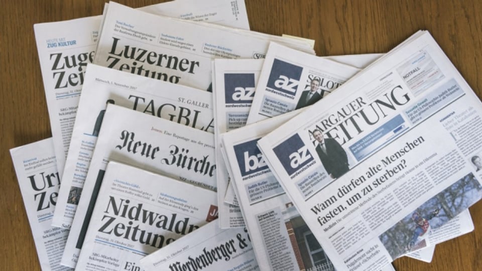  Zeitungen der AZ Medien und der NZZ Mediengruppe liegen auf einem Tisch.