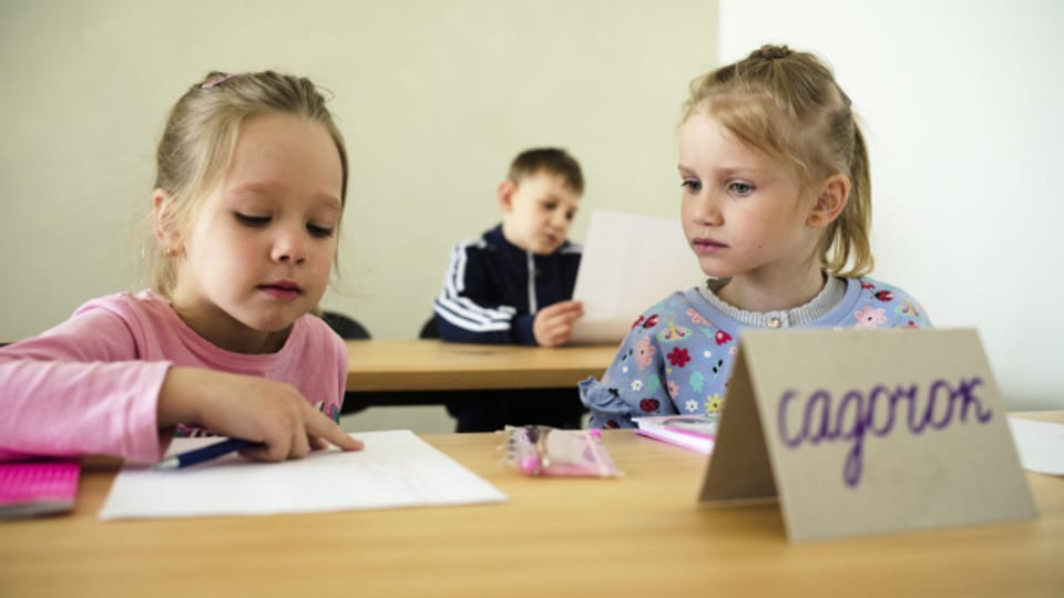 Zwei ukrainische Mädchen sitzen in einer Schule.