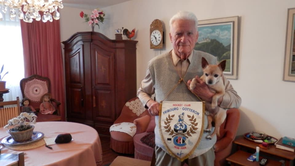 Josef Markwalder mit seinem Hund Lucki und einem Wimpel der 50-Jahr-Feier Gottérons.