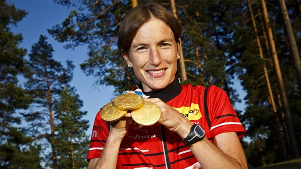 Simone Niggli posiert bei der WM 2013 in Vuokatti mit ihren Goldmedaillen.