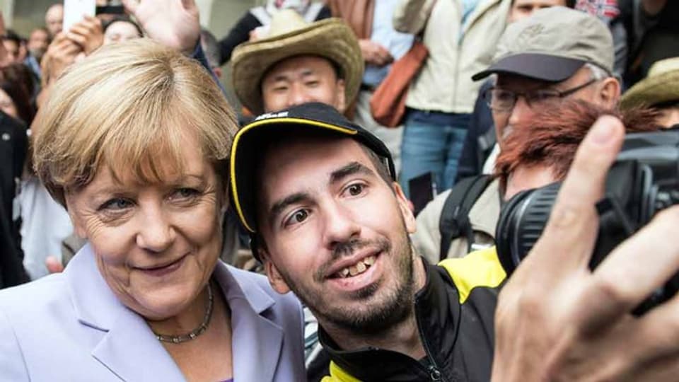 Sie scheint beliebt zu sein: Die Bundeskanzlerin posiert für ein Selfie mit einem unbekannten Mann.