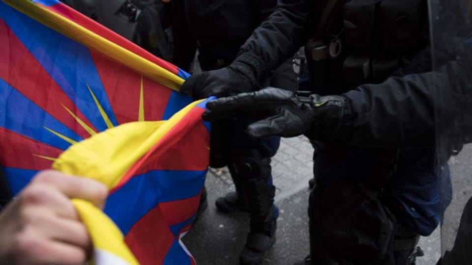 Polizisten senken eine Tibetfahne