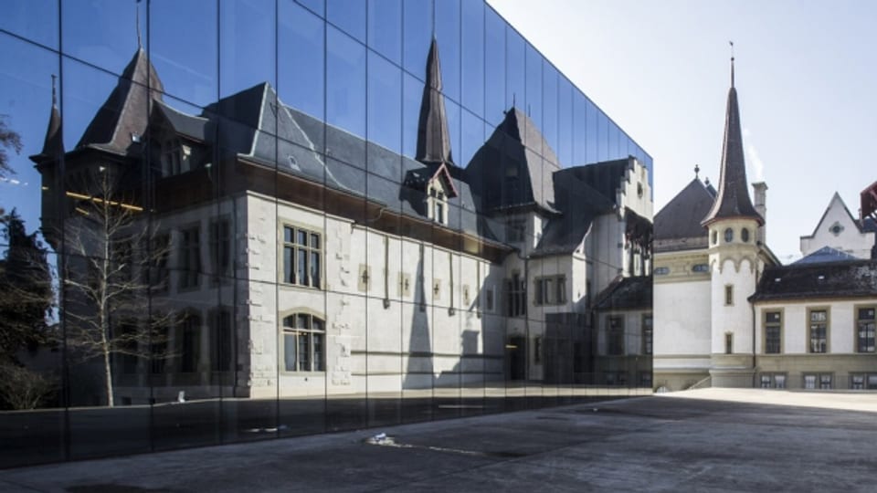 Das Bernische Historische Museum spiegelt sich in der Glasfassade des Stadtarchivs der Stadt Bern.