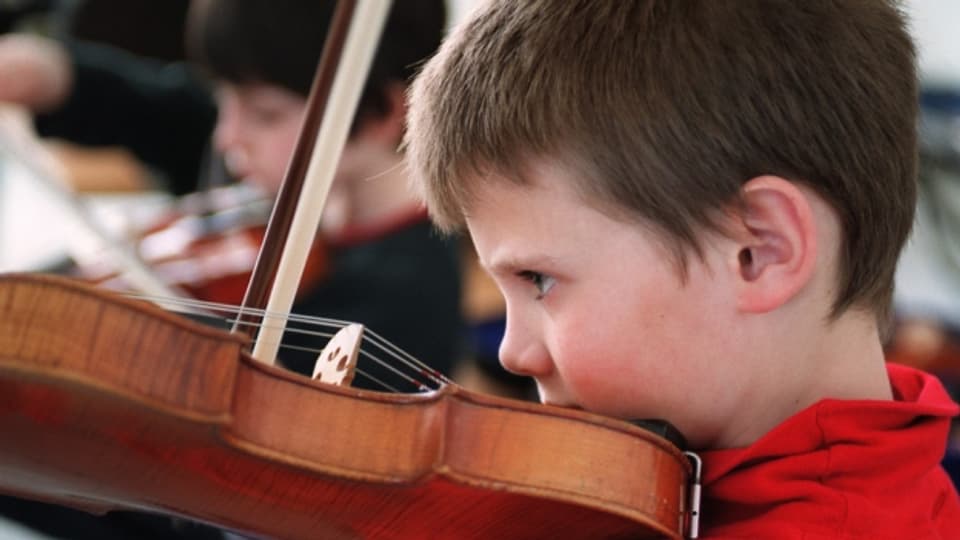 Ein Junge lernt Geige spielen.