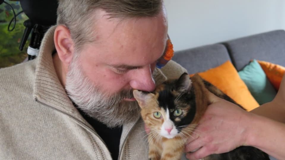Stefan Csombo kann seine Katze nur mit fremder Hilfe streicheln.