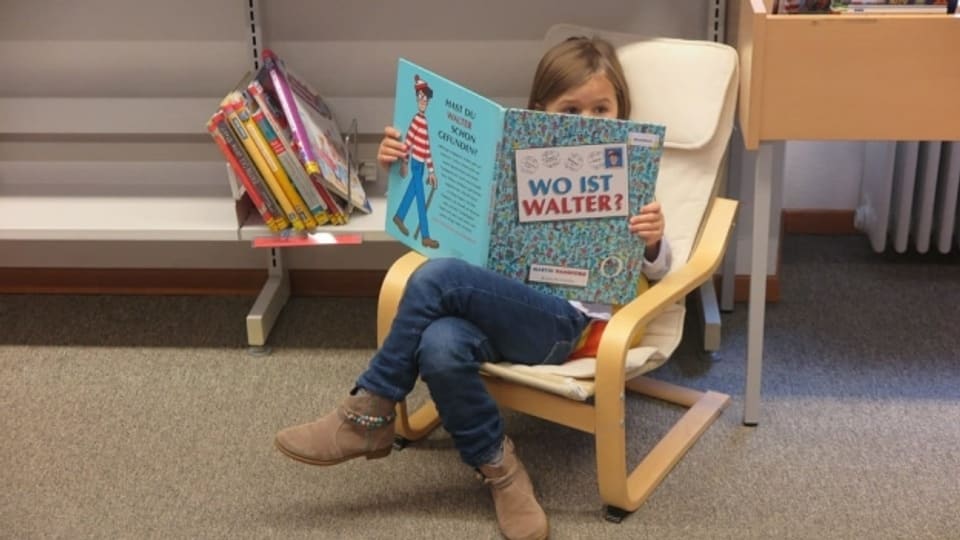 Junge Leseratte in der Bibliothek.