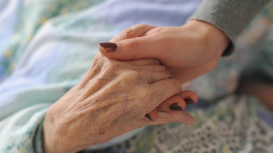 Eine Hand hält die andere. Alltag bei Pflegenden und ihren Angehörigen.
