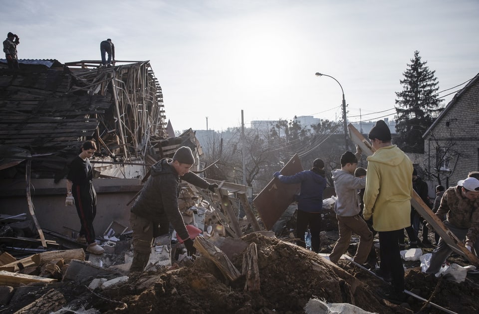 Freiwillige räumen nach einem Raketenangriff in Kiew auf.