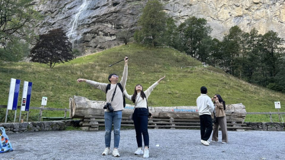 Asiatische Touristen posieren vor den Staubbachfällen.