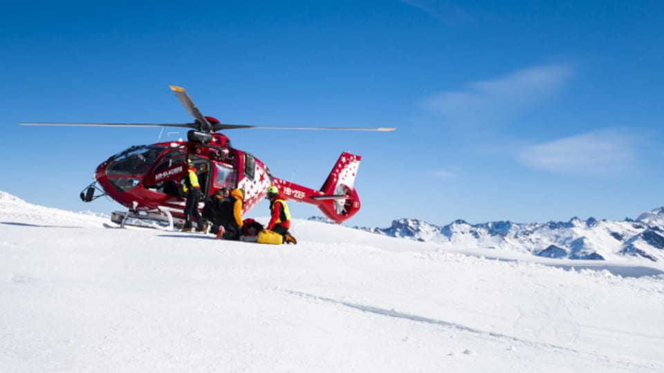 Ein Helikopter bei einer Rettungsaktion auf einer Skipiste.