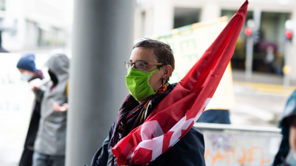 Tonja Zürcher an der Demo mit Mundschutz und Fahne