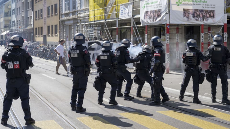 Die Polizei hält mit Gummischrot eine kleine Gruppe Demonstrierende vom SVP-Anlass fern