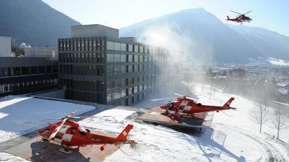 Drei Rettungshelikopter stehen auf dem Gelände des Spitals.
