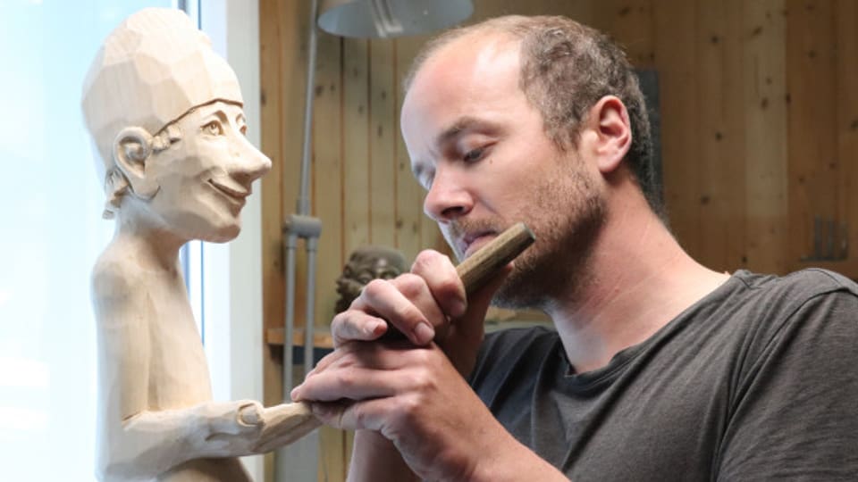 Peter Bissig mit einer seiner Holzfiguren.