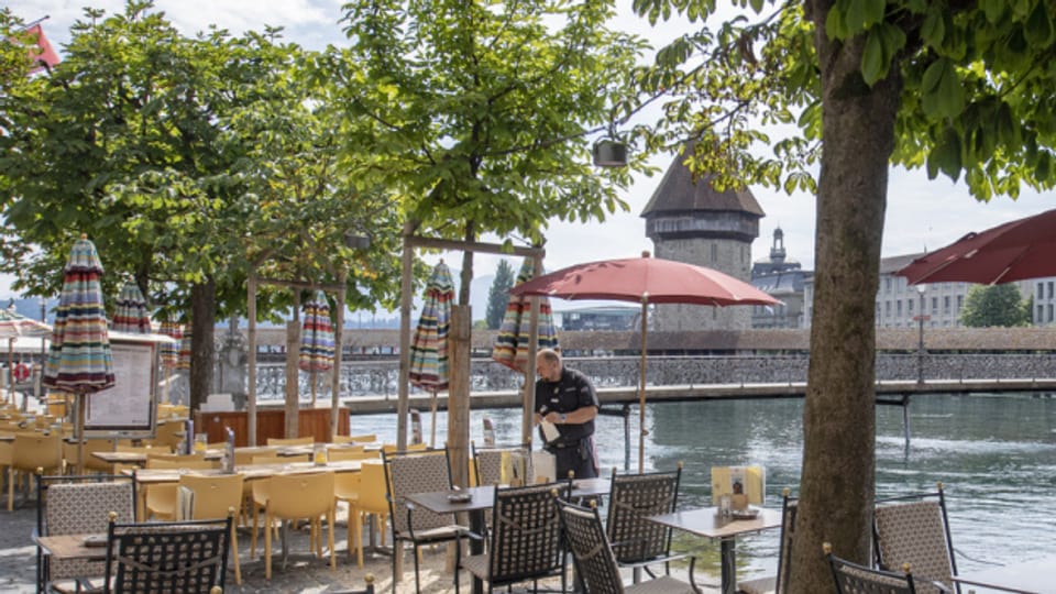 Restaurant-Mitarbeiter in Luzern richtet Tische.