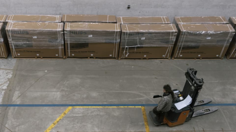 Weniger Firmen in der Industrie: Ein Angestellter begutachtet vom Gabelstapler aus eine Reihe Kisten, die zur Auslieferung bereit sind.