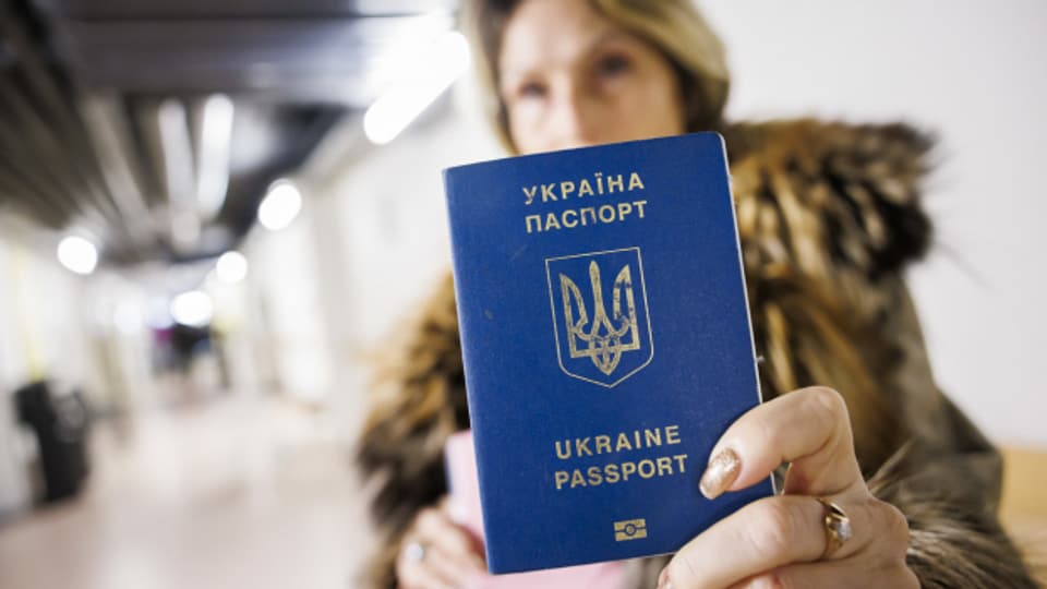 Eine geflüchtete Frau zeigt ihren ukrainischen Pass.