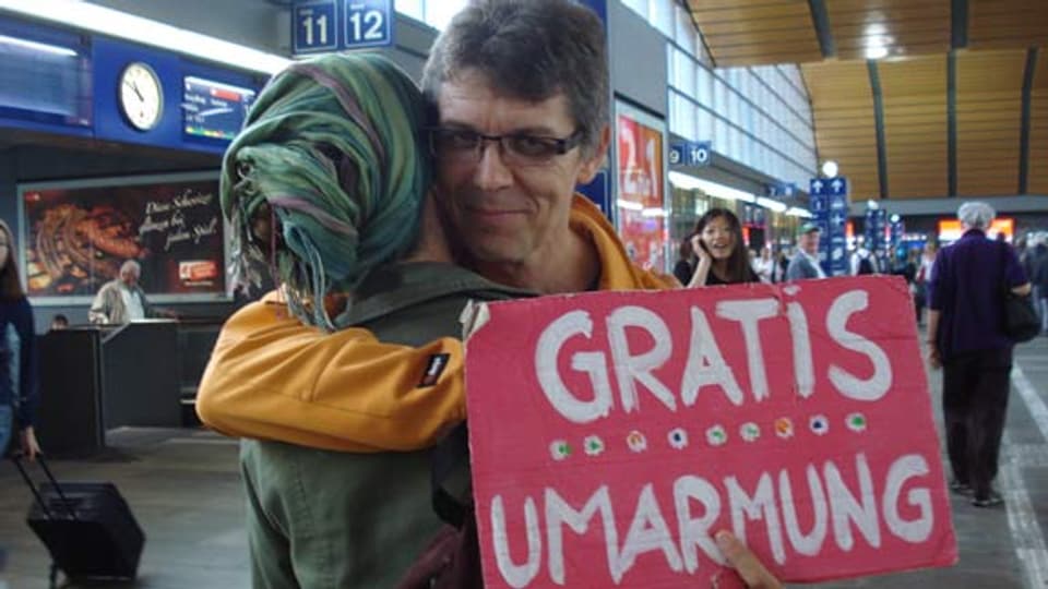 Daniel Krieg umarmt eine fremde Frau im Bahnhof Basel