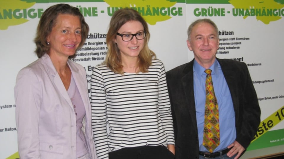 Drei Kandidatinnen und Kandidaten vor dem Logo der neuen Baselbieter Partei Grüne-Unabhängige
