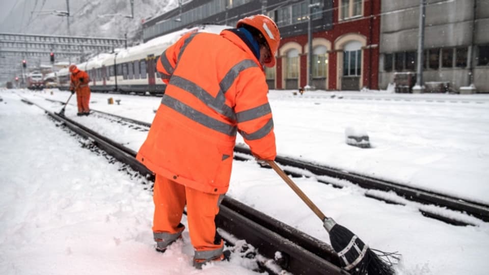 Bahnarbeiter befreien die Gleise am Bahnhof Bellinzona vom Schnee.