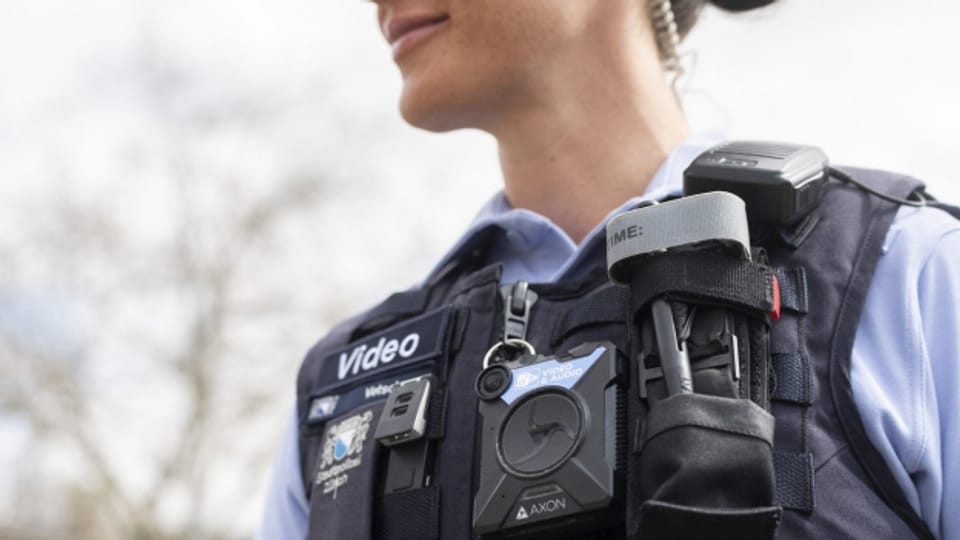 Eine Zürcher Stadtpolizisten posiert mit einer Bodycam.