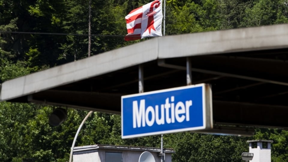 Eine Jura-Fahne und die Ortstafel von Moutier.