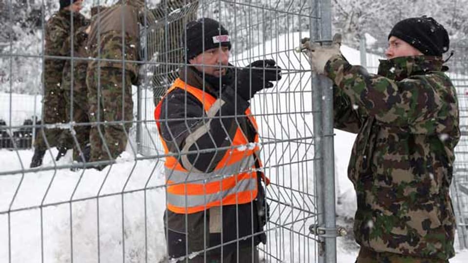 Soldaten fixieren einen Gitterzaun in Davos
