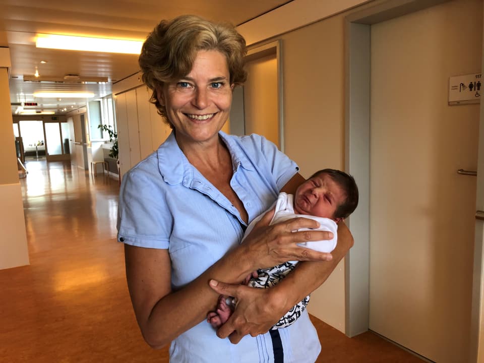 Hebamme Madeleine Grüninger hält das letzte Heidner-Baby in den Armen