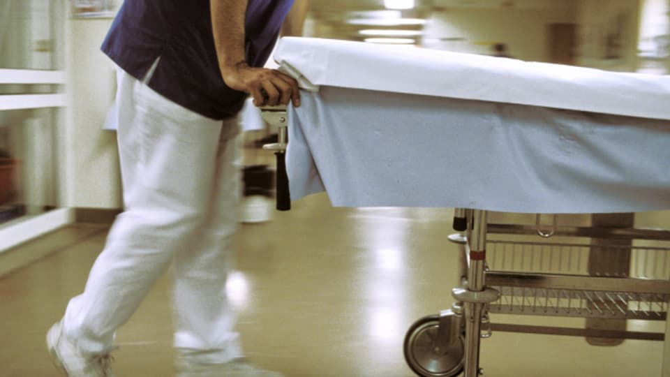 Ein Krankenpfleger schiebt eine Trage in ein Krankenhaus.