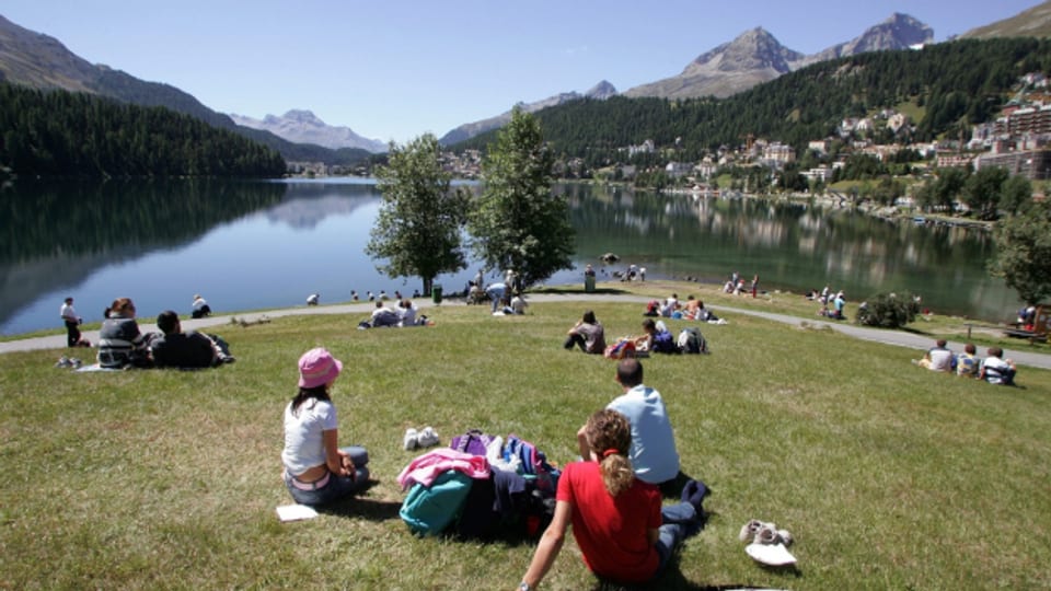 Touristen geniessen das Sommerwetter am Ufer des St. Moritzersees.