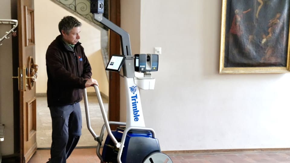 Ein Geomatiker schiebt den Laserscanner durch jeden Raum des Stiftsbezirks St.Gallen.