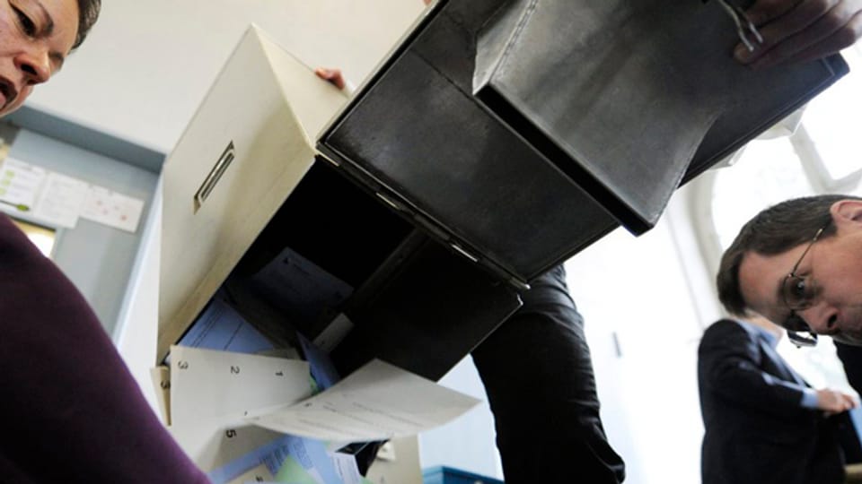 In Zürich wird eine Stimmzettelurne ausgeleert vor dem Zählen.